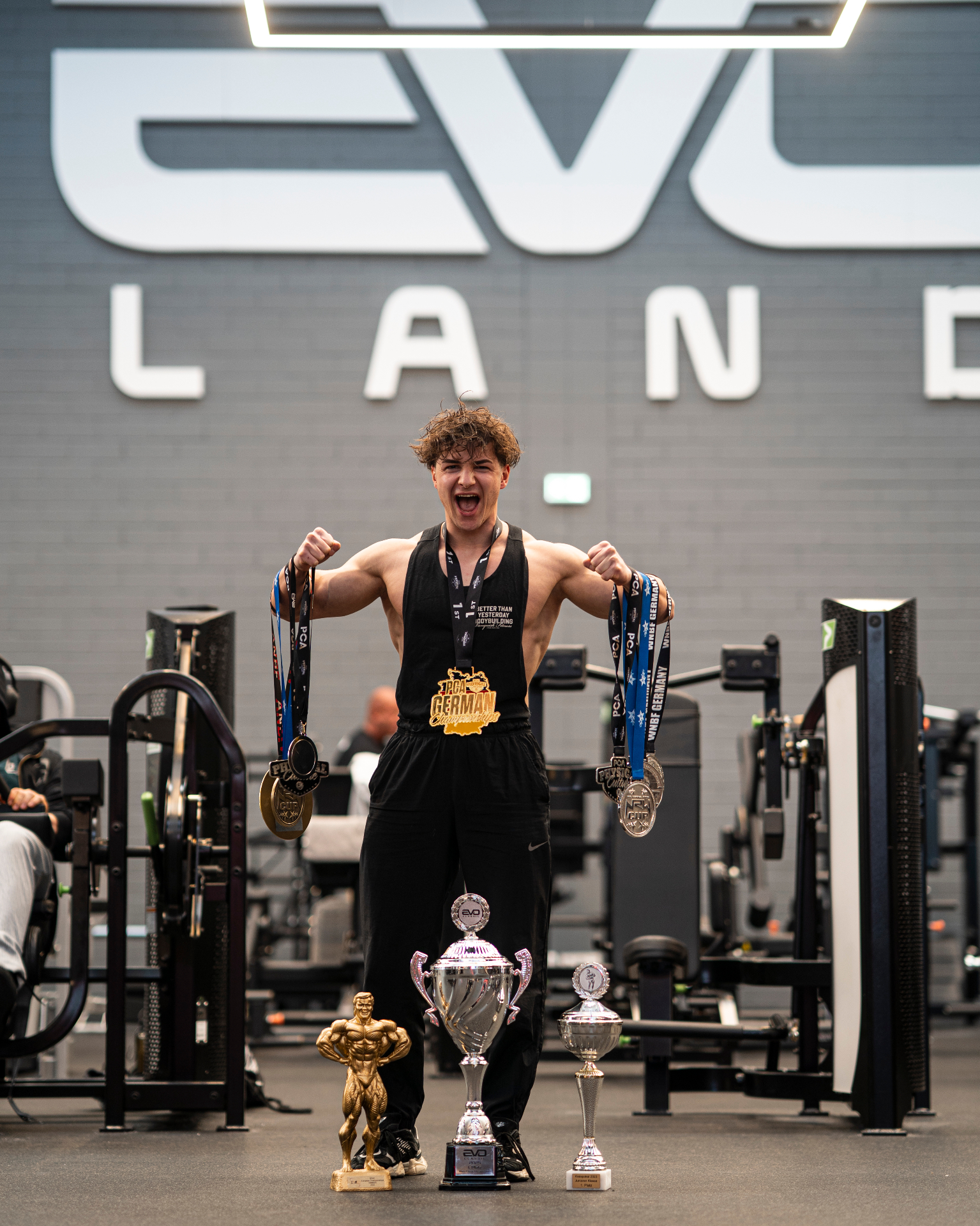 Stefan Gorgiev holding medals with championship trophies